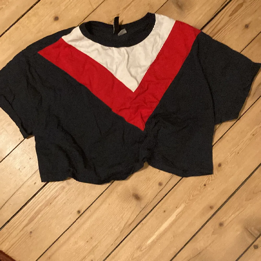 Röd, vit och mörk blå magtröja som kan passa storleker 36-42. . T-shirts.