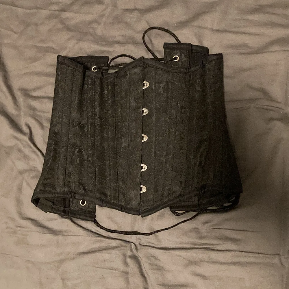 Jättefin Svart korsett med vackert mönster i bra kvalitet från corsets-uk. Köpt second hand men aldrig använd pga att den är för liten.. Accessoarer.