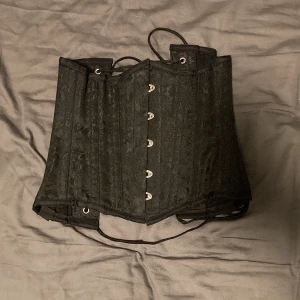 Svart korsett - Jättefin Svart korsett med vackert mönster i bra kvalitet från corsets-uk. Köpt second hand men aldrig använd pga att den är för liten.