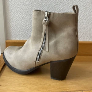 Mocka-stövletter - Beiga stövletter i mocka material med en dragkedja-detalj.  Bekväma klackskor.  Använd ett fåtal gånger.