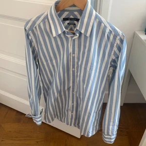 Tiger of Sweden Randig Sommarskjorta - Helt slutsåld! Nypris: Ca 1500 kr Mycket bra skick! 1 knap har lossnat, men finns extra knapp som lätt kan sys på Storlek: 40 (S-M) 