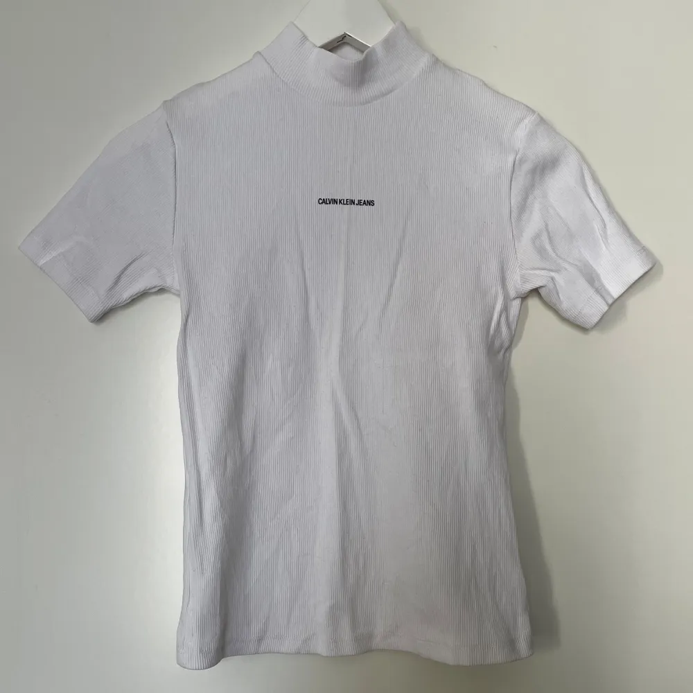 Calvin Klein ribbad t-shirt med halvpolo. Använd 1 gång!. Toppar.