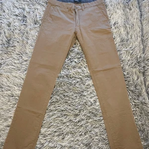 Chinos Dressman - Chinos Dressman Herr Strlk.33/36 (Beige) Säljer byxorna för jag rensar garderoben och inte använt dem på länge. De är i använt skick men inga defekter eller missfärgningar överhuvudtaget. -Midja 43 Cm -Längd 114 Cm