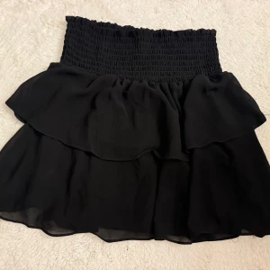 Svart Volangkjol - Svart Volangkjol från Chelsea, storlek M men passar oxå S Väldigt lite använd