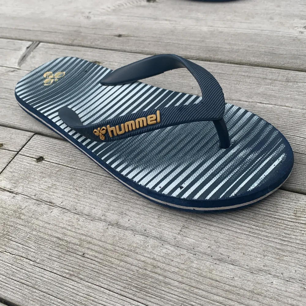 Vit och blårandiga Hummel flipflops för barn 8-13 år. Passar väldigt bra för en dag på stranden.. Skor.