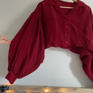 Croppad skjorta med ballongärm - Suuperfin croppad skjorta i lite blankt tyg. älskar denna men den är tyvärr lite för stor för mig 💔 Fint skick!  💫 Kolla gärna in min profil, jag har lagt upp massa nya grejer! 💫