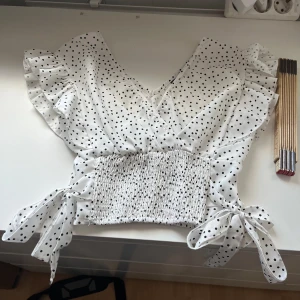 Vit prickig blus - Bra skick. Knappt använd. Fin till sommaren. Hör av er vid frågor. Pris kan diskuteras! 
