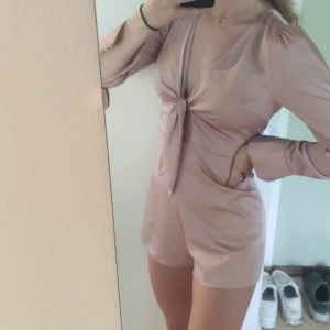 Fin jumpsuit från bikbok - Ljusrosa jumpsuit i sidenliknnade material från bikbok i storlek xs. Knyts framtill och har öppen rygg. Har några tråddragningar nedtill bak men ingenting man tänker på (se bild). 