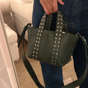 Supersnygg väska! - Säljer nu min fina väska från get the gallop, då jag tyvärr inte får användning för den längre. Den är äkta läder och nypris är 1999kr. men slut i alla färger. Den är grön med nitar, och långt band medföljes.