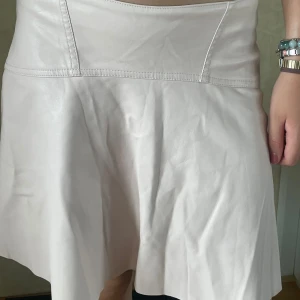 Rosa skinn kjol - Supersöt kjol. Den ser vit ut men är egentligen ljusrosa. Skinn material. Bra skick. 