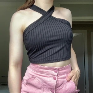 Svart topp - Svart ribbad topp. Kroppad och är i storlek M. Snören som går omlott runt halsen. Inga defekter och är köpt på Sellpy🖤