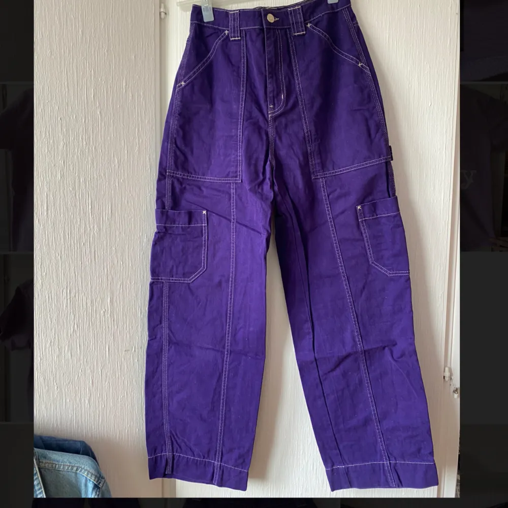 Lila byxor från Weekday med tydliga sömmar, storlek 34. Jeans & Byxor.