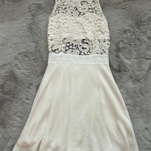 Vit klänning - En super fin vit klänning, använd någon gång men inga defekter eller andra fel på den, normal i storlek. Inte alls genomskinlig och svalt material som är skönt på sommaren. Öppen rygg med fina detaljer och dragkedja.