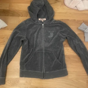 Grå juicy couture zip up  - Så snygg juicy couture zip up med sjukt snygga detaljer och rhinestones. Köpt på vinted men i nyskick, storlek M men passar mig med S perfekt, tror även den passar xs💓pris går att diskuteras!