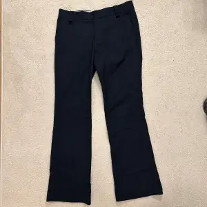 Mörkblå kostymbyxor i bootcut från mango, mid waist. Hittar ingen storlek men skulle gissa på L. Innerbenslängd: 80 cm, midjebredd: 41 cm.