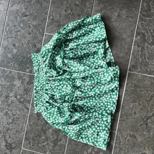 Grön blommig minikjol - Grönblommig minikjol från märket princess polly. Inga tecken på användning🍀