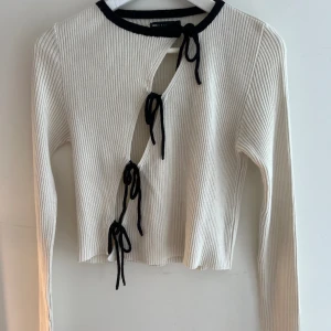 Vit tröja med rosetter - Superfin vit stickad tröja från asos med svarta rosetter. Endas använd fåtal gånger och sitter bra på mig som bär M. 