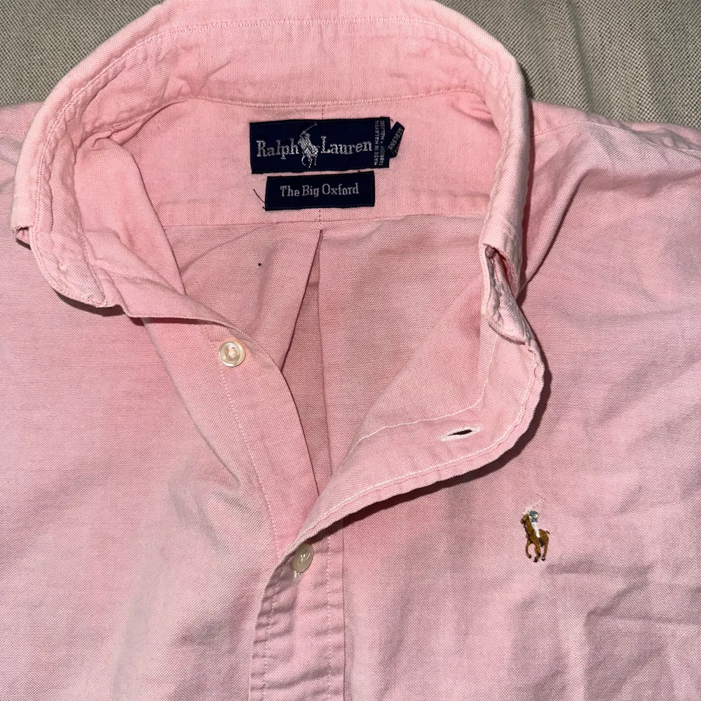 Säljer min Rosa Oxford skjorta. Den är en lite bredare modell än den vanliga Ralph Lauren Oxford skjortan men passare perfekt till den som inte vill att skjortor sitter på tajt.. Skjortor.