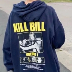 Svart hoodie med Kill Bill tryck - Mörkblå hoodie med ett coolt Kill Bill tryck på baksidan. Den har en stor bild från filmen och texten 'KILL BILL VOLUME 1' i gult. Hoodien är i bra skick och passar perfekt för höst och vinter.