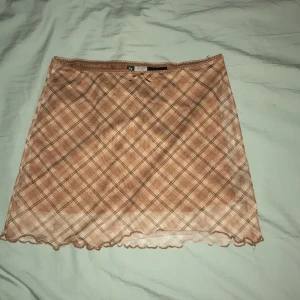 brun rutig mesh kjol - Brun kjol av mesh. Den är rutig, har spets o en liten rosett högst upp. köpt på h&m. storlek xxs. pris kan diskuteras🤎