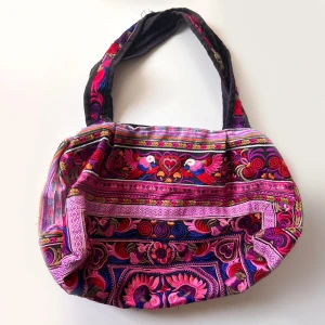 Färgglad axelväska med broderier - Säljer en superfin och färgglad axelväska med vackra broderier i rosa, lila, blå och röda nyanser. Den har en liten ficka på insidan. jag har sytt in sidorna för att göra den mer rund (bild 5). Klicka på köp nu <3