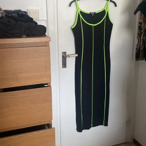 Svart och neongrön klänning  - Klänning från Missguided. Är figursydd och sträcken framhäver kurvor. Säljer för att det ej är min stil längre. Tror någon annan har bättre användning för den. Har knappt använt den så den är i bra skick👍🏻