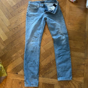 Ljusblå jeans från BLK DNM - Ett par ljusblå jeans från BLK DNM. Jeansen har en klassisk femficksdesign och är tillverkade i denim. De har en dragkedja och knapp framtill.