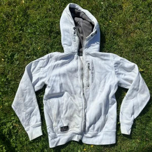Vit hoodie från Sail Racing - Säljer en vit hoodie från Sail Racing i storlek Small. Den har en dragkedja framtill och en liten ficka med dragkedja på bröstet. Dragkedjorn är trasiga därav pris.  Den ha enstake fläckar på koftan. Övrigt bra kofta🌸