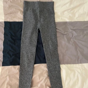 Grå leggings från BikBok - Säljer ett par grå leggings från BikBok i storlek XS/S. De är superbekväma och stretchiga, perfekta för både vardag och träning. Materialet är en blandning av polyester och elastan vilket gör dem mjuka och följsamma. De är i bra skick och redo för en ny ägare!