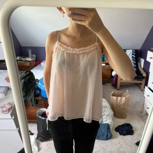 Ljusrosa linnetopp - En ljusrosa linnetopp med smala axelband och rynkad detalj vid halsringningen💕har en lös passform. ifrån Gina tricot🫶🏻i bra skick. använd gärna köp nu💌