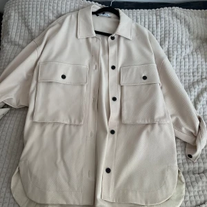 Skjortjacka från Zara  - Storlek M men passar även S, oversized.  Beige med svarta knappar. Använd fåtal gånger. 