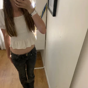 Vit croppad topp från Kappahl - Säljer en söt vit croppad topp från Kappahl. Toppen har korta ärmar och en volangdetalj vid midjan. Perfekt för sommaren och kan stylas med både jeans och kjol. Toppen är i bra skick och redo för en ny ägare!