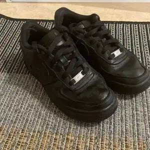 Säljer ett par svarta Nike Air Force sneakers i storlek 36,5. Skorna är i bra skick med några mindre tecken på användning. . Perfekta för vardagsbruk eller träning.