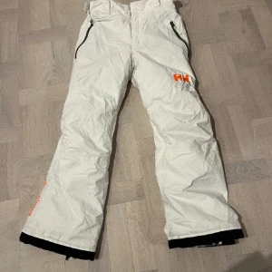 Vita skidbyxor från HH - Ett par vita Helly Hansen skidbyxor  Super sköna och varma och ett bra skidmatreal Tål vatten bra och är sköna att åka i 🤍🤍Nästan helt oanvända- Pris kan diskuteras Storlek 164 - om den köps tillsammans med jackan säljer jag båda för 750 totalt 