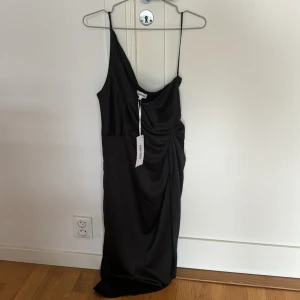 Svart satin klänning - Svart one shoulder satin klänning från bubbleroom helt oanvänd.