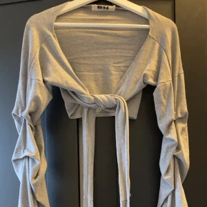 Dennis maglic - Lite sliten haft den länge men ser inte sliten ut när man har på sig den, det är en tröja som man kan knyta på olika sätt. Man kan ha den över klänningar också och är one- size.