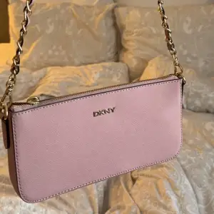 Super fin väska från DKNY, måtten är 12x23, följer med 2 st band som båda är avtagbara (ena är ca 110cm men kan ställas om, den andra är ca 50cm) fint skick💗