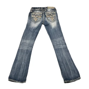Rockrevival Jeans - Sjukt snygga rockrevival jeans i storlek 25. Midja:35cm Ytterbenslängd:97cm, innebenslängd:75cm, benöppning:20cm. Tyvärr har vi inga bilder hur de sitter på så jämför gärna måtten med ett par egna byxor.Finns en liten fläck som vi kan skicka på dm💫