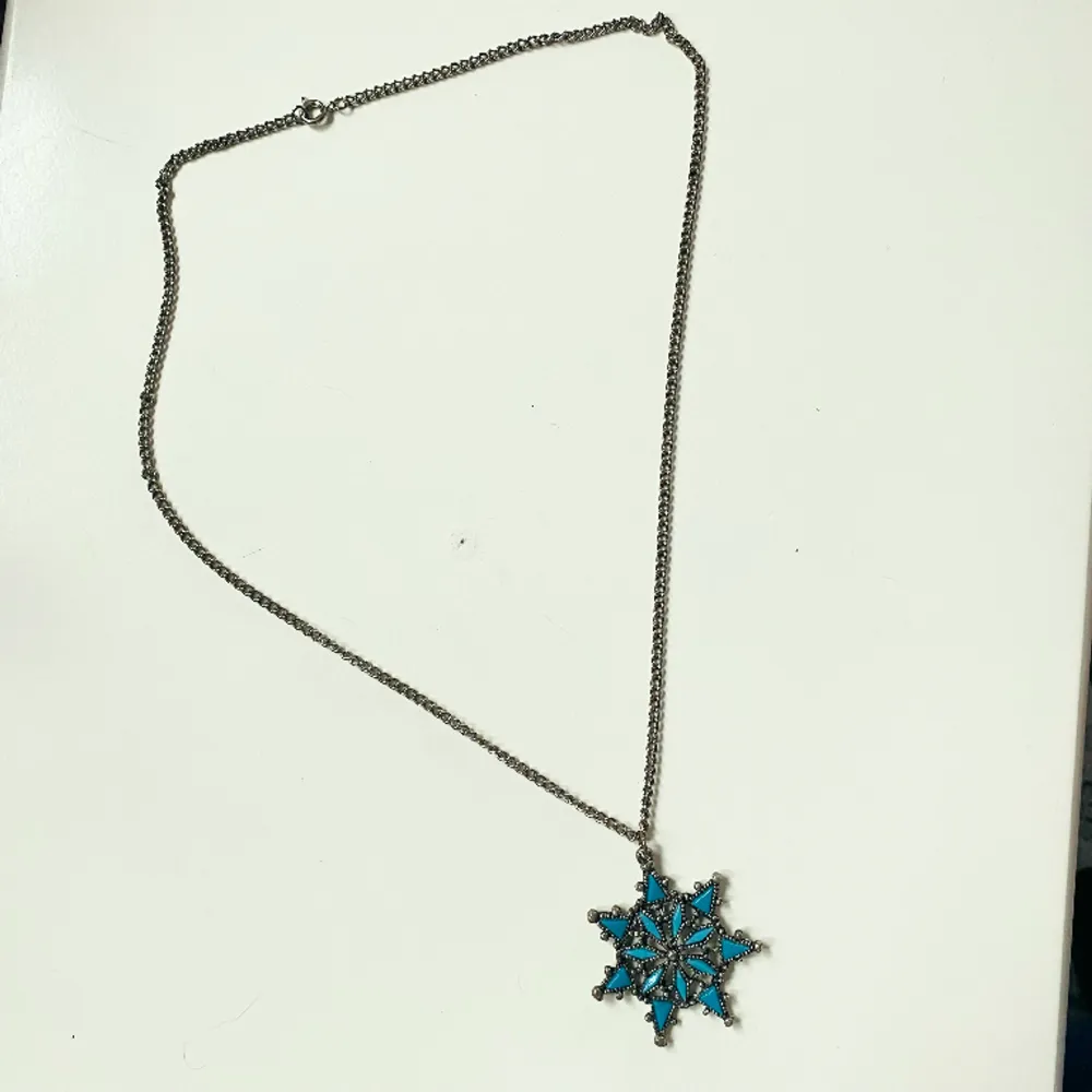 Vackert halsband med turkosa detaljer i stjärnhänge  Okänt material  Kedjan ca 60 cm Hänge 5 cm. Accessoarer.
