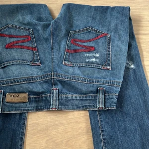Lågmidjade zoul bootcut jeans - Säljer dessa snygga Lågmidjade utsvängda bootcut jeansen från märket zoul då de tyvärr inte kommer till användning längre, de är i jätte bra skick och ser oanvända ut, och sitter jätte snyggt och passar många olika storlekar, skriv för mer info