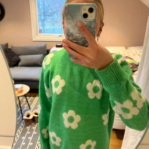 Grön tjocktröja med vita blommor - Jag säljer min fina gröna tröja med vita blommor pga att det inte längre är min stil. Väldigt fint skick och inga defekter. Som du ser på bild tre så är den lite, lite nopprig. Passar nog de flesta storlekar eftersom att den är lite oversize💕