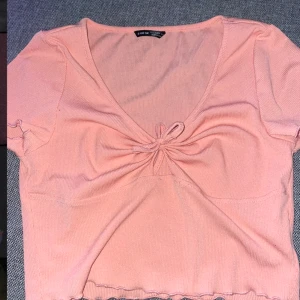 Topp - Jätte fin orange topp med snörning i mitten. Ribbat tyg och man kan knyta banden hur man vill. Väldigt sommrig. 