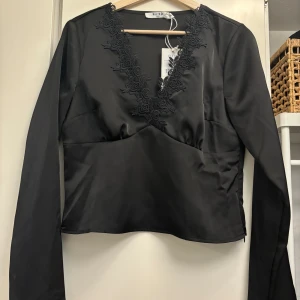 Svart blus med spetsdetaljer - Snygg svart blus, helt oanvänd.
