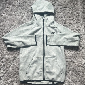 Nike Tech Fleece Grå Storlek L Oanvänd - Helt oanvänd, fick den av en vän men den är inte riktigt min stil och den passar inte mig (jag brukar ha S eller M) så säljer den. 10/10 skick asså helt ny i princip. Skickar samma dag om du köper innan kl 20. Mvh