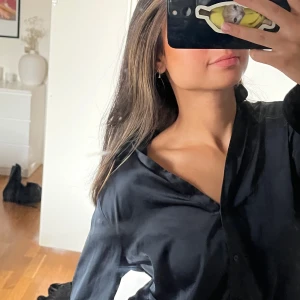 Satin skjorta - En svart/blå satin skjorta