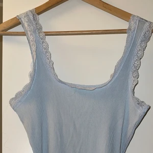 Kort blå klänning  - Helt ny, oanvänd med prislapp kvar  Kort blå klänning med spets detalj  Storlek L (kan passa M) 