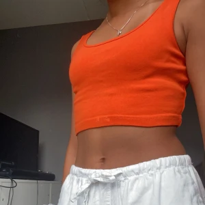 Cropat linne - Jättesnyggt orange linne ifrån GinaTricot🧡 Väldigt stretchigt material, storlek S, men passar även XS. Använd Max 5 gånger och är i fint skick😍 Skriv vid frågor!🫶