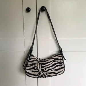 Axelväska  - En jättesöt zebramönstrad axelväska köpt från Ginatricot♥️ Hör av er för fler frågor!