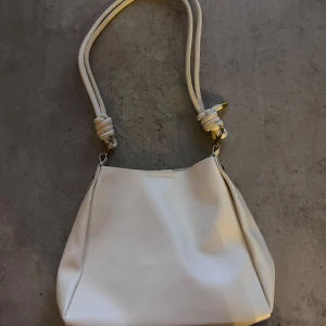 Vit väska  - Jättefin väska som är köpt från SHEIN. Det är lite märken på ena sidan men det går bra att använda den andra sidan utåt! Mått: 23,5x9,5x23,5cm 