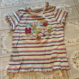 Randig tröja med motiv - Randig tröja med motivet: BE HAPPY. Storlek 80 från ”Little GIRLSTAR”. Använd några gånger.